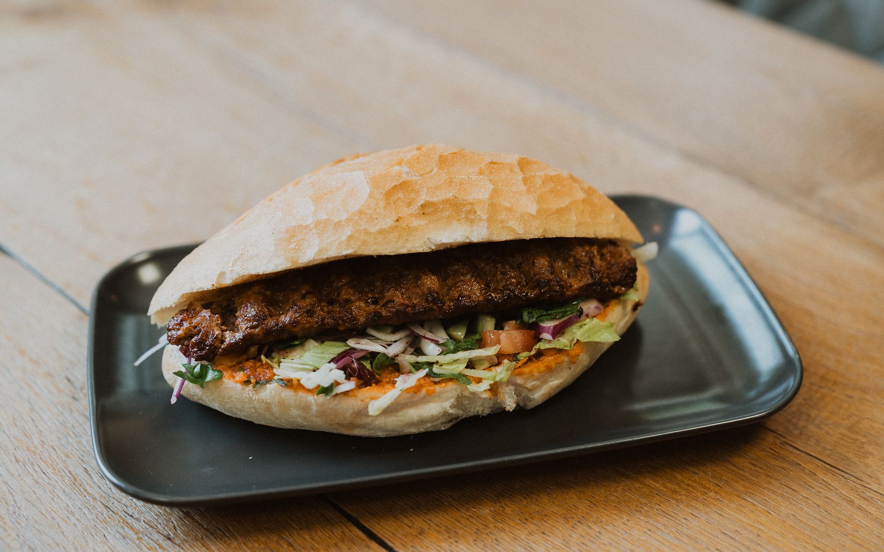 Adana Sandwich im Fladenbrot mit Salat, Tzaziki und scharfer Sauce
