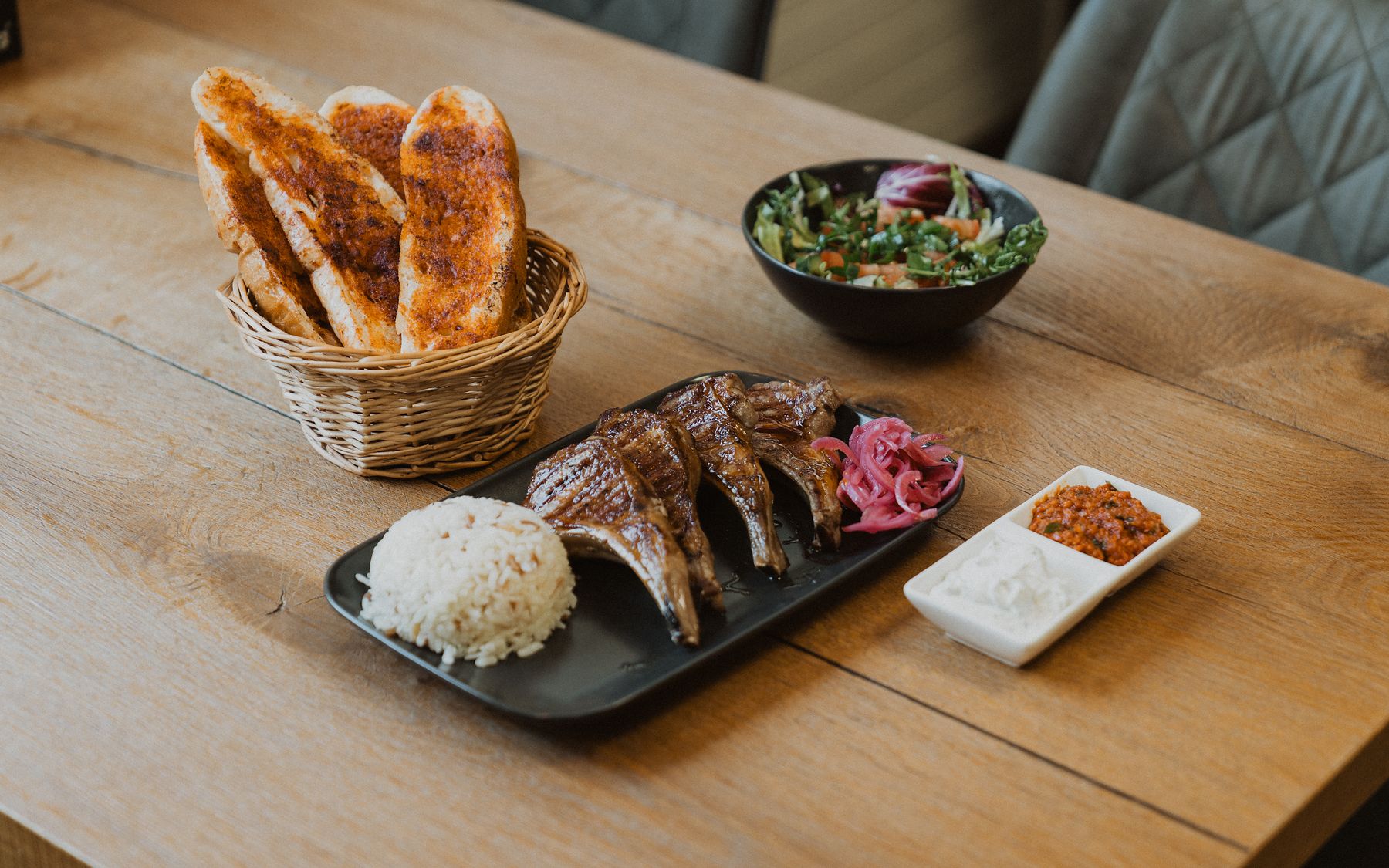 Lammkotelett vom Holzkohlegrill mit Reis, Fladenbrot und eingelegten Zwiebeln
